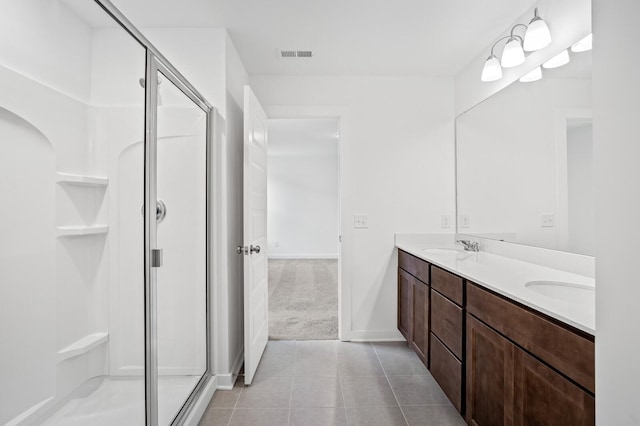 bathroom with visible vents, double vanity, baseboards, tile patterned floors, and a shower stall