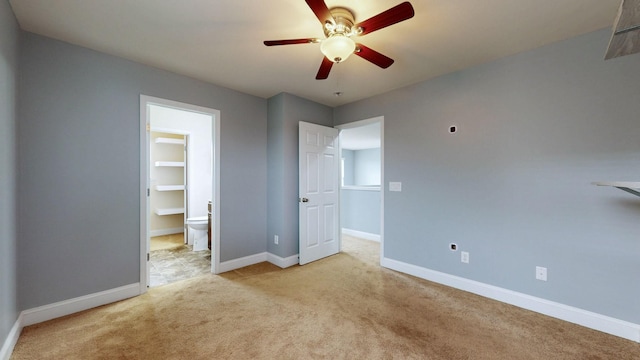unfurnished bedroom featuring baseboards, carpet flooring, connected bathroom, and ceiling fan
