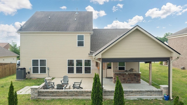 rear view of house with central air condition unit, a lawn, and a patio area