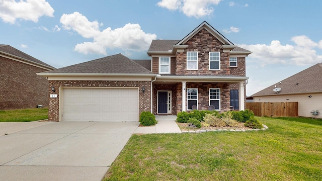 view of front of house with driveway, a front yard, fence, an attached garage, and stone siding