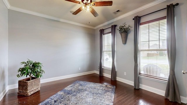 unfurnished room featuring dark wood-style flooring, ceiling fan, baseboards, visible vents, and ornamental molding