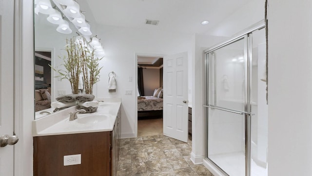 full bathroom with double vanity, visible vents, a shower stall, a sink, and connected bathroom