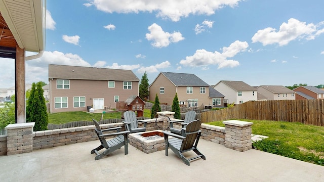view of patio featuring a residential view, fence, and an outdoor fire pit