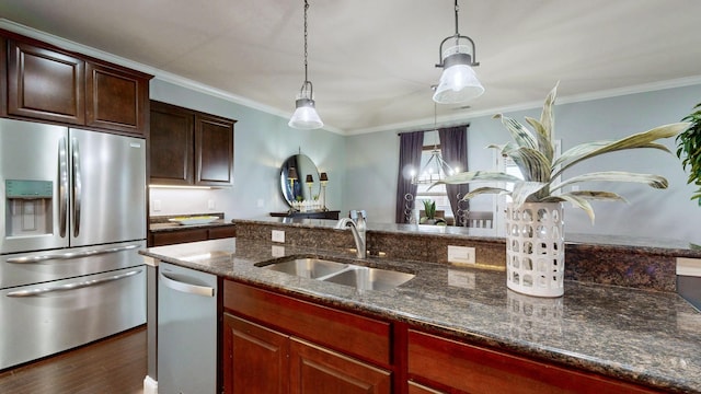 kitchen featuring ornamental molding, dark wood-style floors, dark stone counters, a sink, and stainless steel appliances