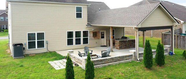 rear view of house with area for grilling, a patio, and a lawn