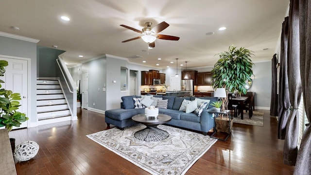 living area with baseboards, a ceiling fan, crown molding, and visible vents