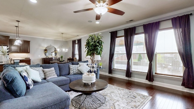 living area with a healthy amount of sunlight, baseboards, ceiling fan with notable chandelier, and visible vents