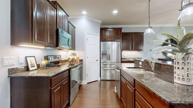 kitchen with dark brown cabinets, a sink, dark stone countertops, stainless steel appliances, and ornamental molding