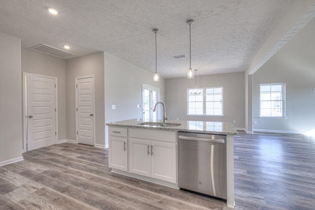 kitchen featuring a textured ceiling, visible vents, a sink, and dishwasher