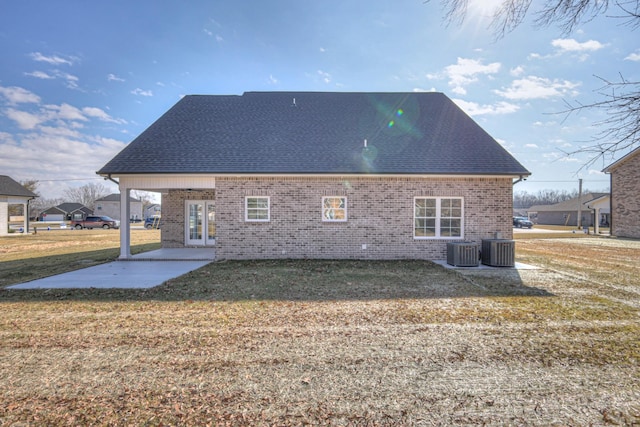 back of property featuring brick siding, central AC, and a patio