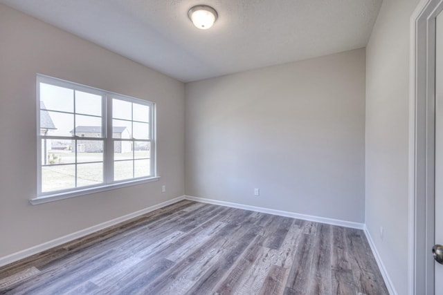 unfurnished room featuring baseboards and wood finished floors