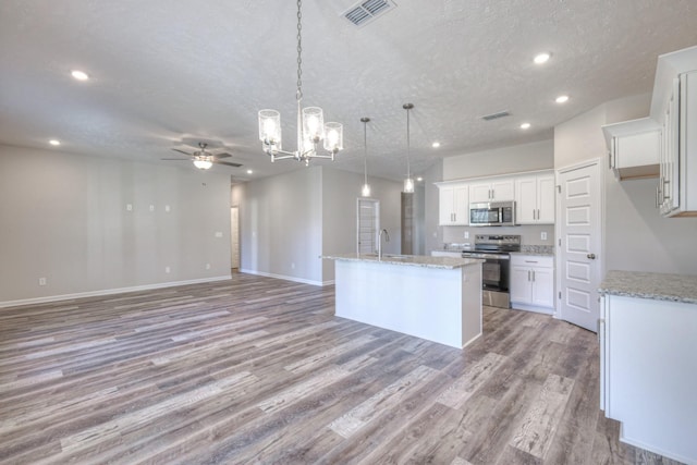 kitchen with visible vents, recessed lighting, light wood-style flooring, ceiling fan with notable chandelier, and stainless steel appliances