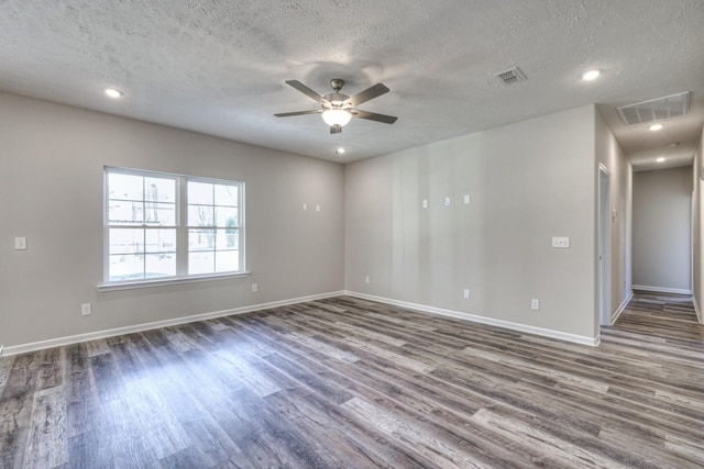 spare room featuring ceiling fan, visible vents, and wood finished floors