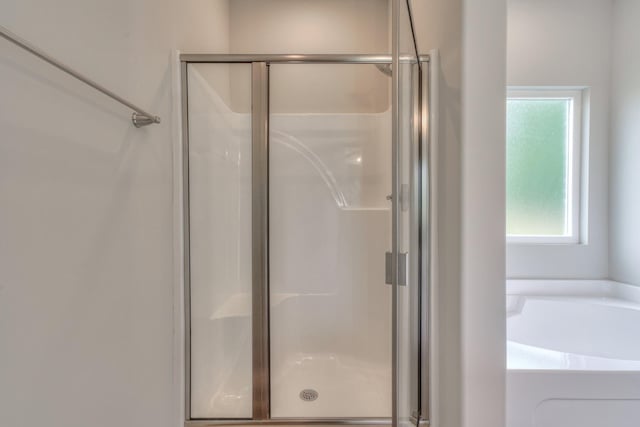 bathroom featuring a shower stall and a garden tub