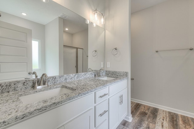 full bath featuring baseboards, a sink, wood finished floors, and a shower stall