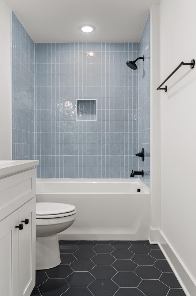 bathroom featuring tile patterned floors, vanity, toilet, and  shower combination