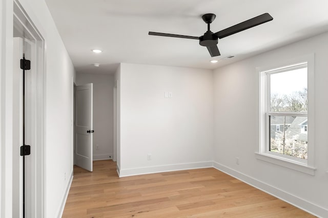 empty room featuring ceiling fan, plenty of natural light, and baseboards
