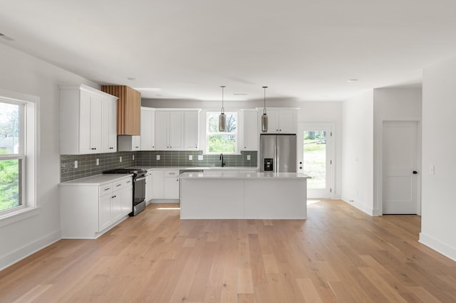 kitchen with light wood-type flooring, decorative backsplash, baseboards, and appliances with stainless steel finishes