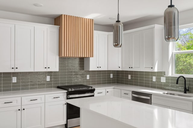 kitchen with decorative light fixtures, a sink, ventilation hood, white cabinets, and stainless steel appliances