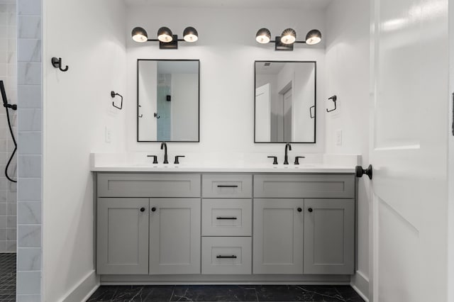 full bathroom with double vanity, baseboards, a sink, and marble finish floor