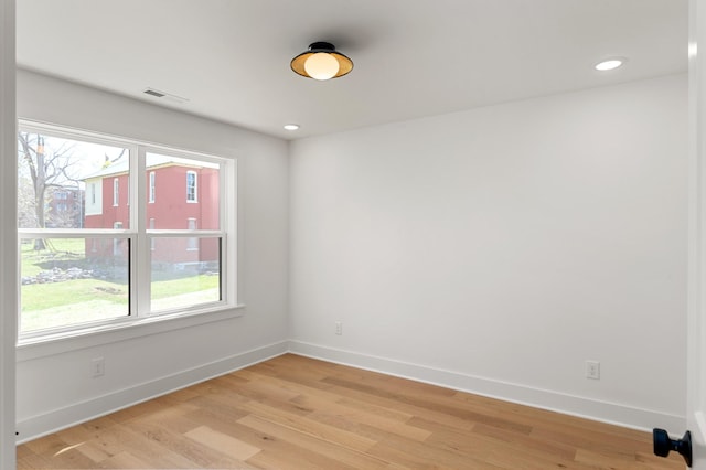 spare room featuring baseboards, a wealth of natural light, and visible vents