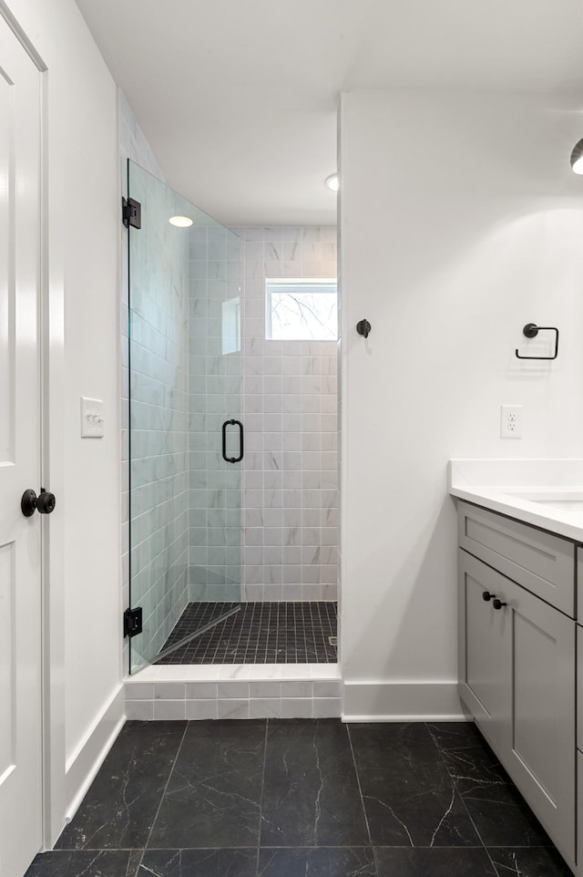 full bathroom featuring baseboards, marble finish floor, vanity, and a shower stall