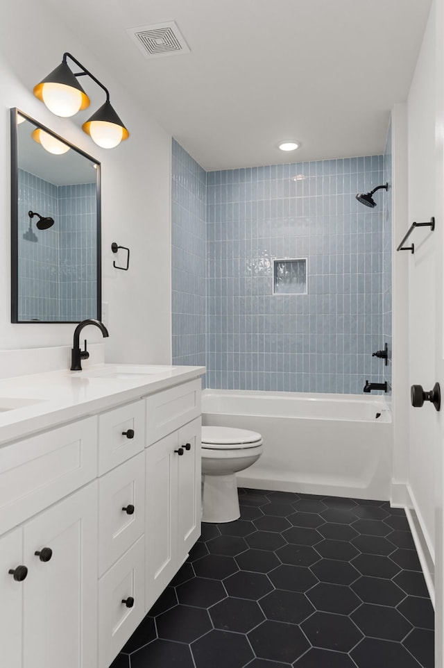 bathroom featuring visible vents, tile patterned floors, vanity, toilet, and washtub / shower combination