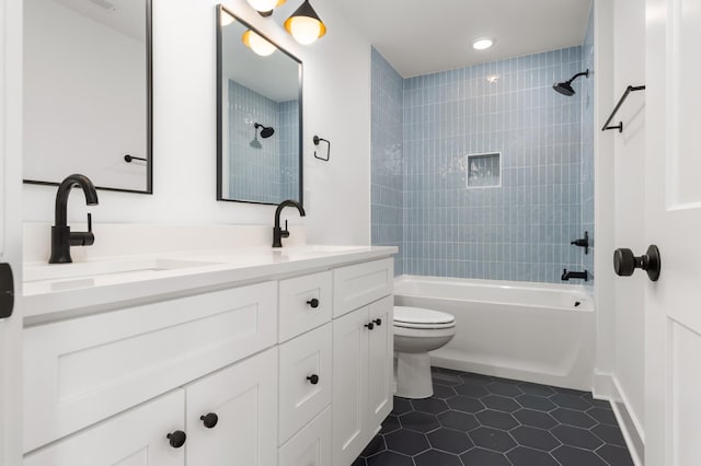 full bath with a sink, tile patterned floors, toilet, and shower / bath combination