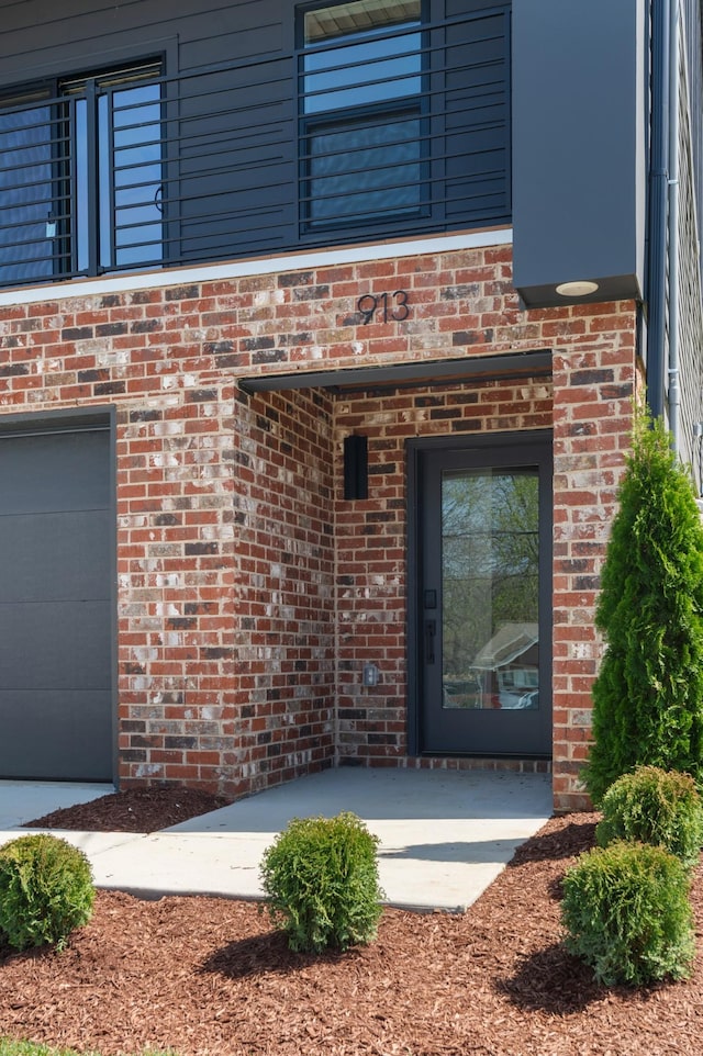 view of exterior entry featuring brick siding