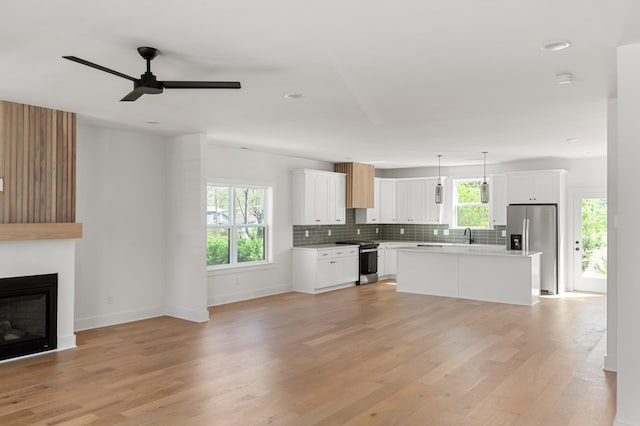 interior space featuring plenty of natural light, light wood-style flooring, and baseboards