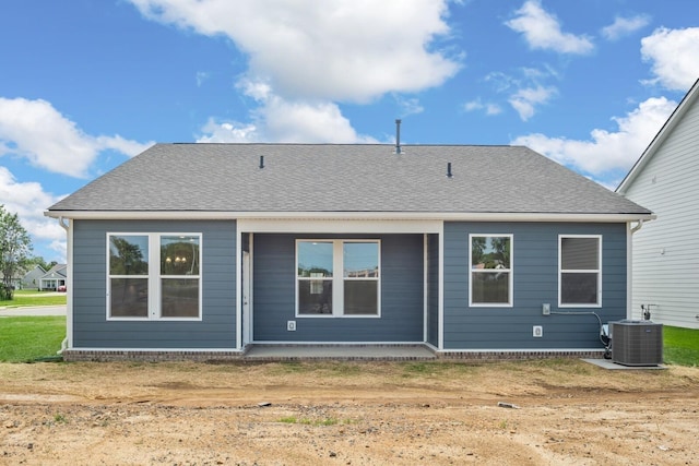 rear view of property with central air condition unit and a shingled roof