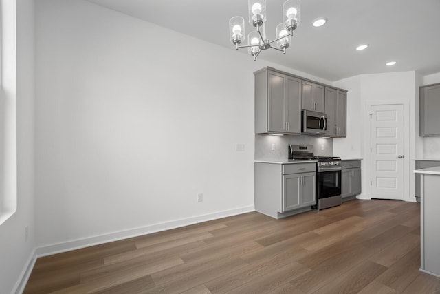 kitchen with recessed lighting, gray cabinets, wood finished floors, and stainless steel appliances