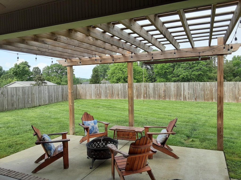 view of patio with a fenced backyard, a pergola, and an outdoor fire pit