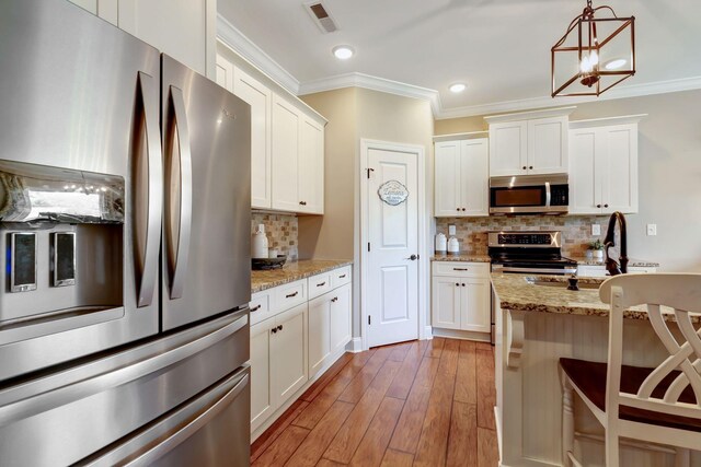 5014 Rainier Dr, Chapel Hill, TN 37034 - kitchen with stainless steel appliances, ornamental molding, backsplash, white cabinets, and light wood-style flooring