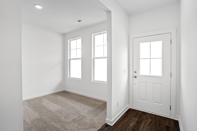 doorway to outside featuring baseboards, dark wood-style floors, and visible vents