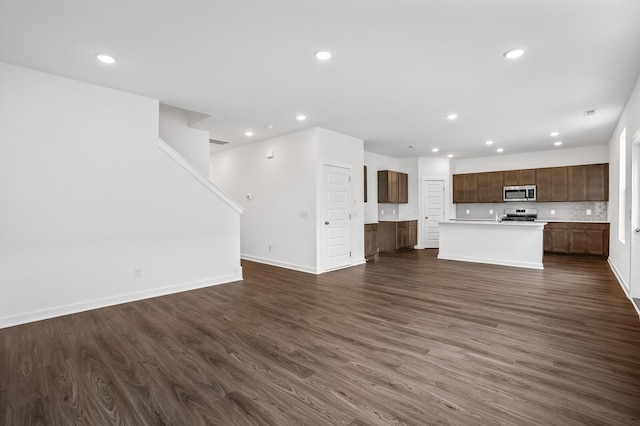 unfurnished living room featuring dark wood finished floors, baseboards, and recessed lighting