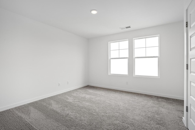 empty room with visible vents, baseboards, and carpet floors