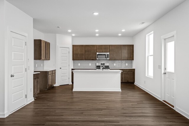 kitchen with backsplash, dark wood-style flooring, light countertops, stainless steel appliances, and recessed lighting