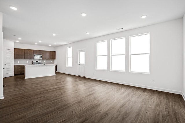 unfurnished living room with baseboards, dark wood-style flooring, recessed lighting, and visible vents