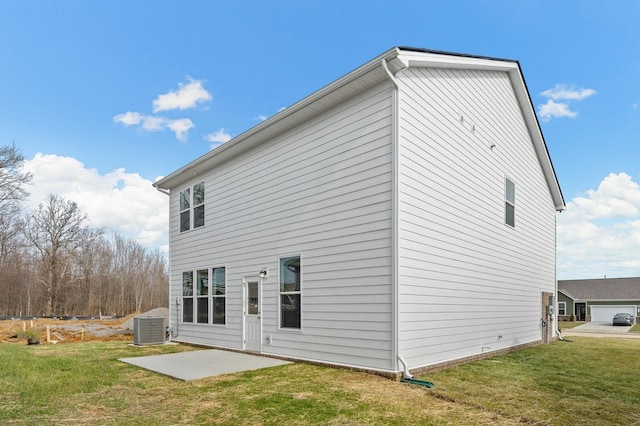 rear view of house with central AC unit, a patio area, and a yard
