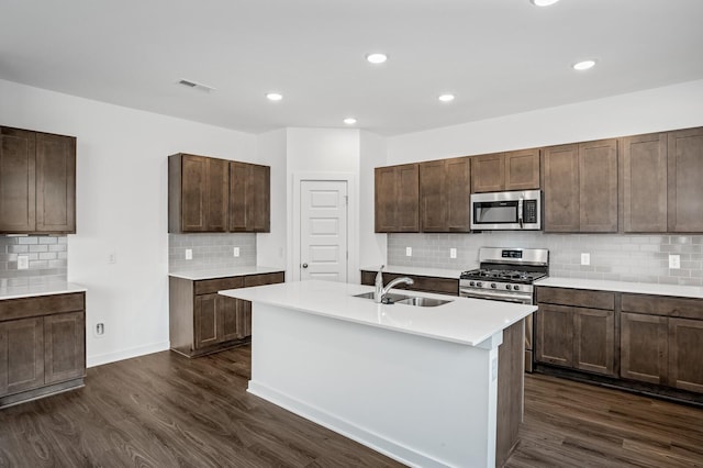 kitchen featuring dark wood-type flooring, a sink, appliances with stainless steel finishes, and backsplash