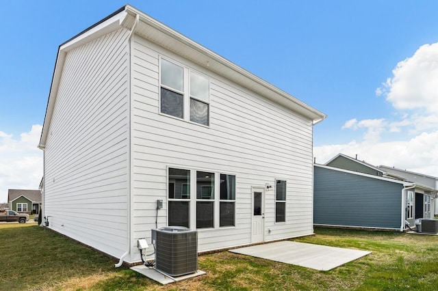 back of house with central AC unit, a yard, and a patio area