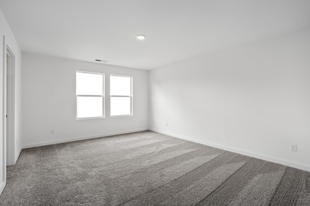 spare room featuring carpet flooring, recessed lighting, baseboards, and visible vents