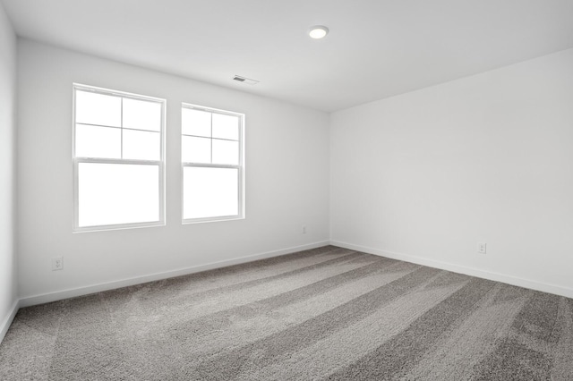 carpeted empty room with baseboards, recessed lighting, and visible vents