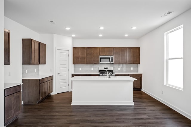 kitchen featuring visible vents, dark wood finished floors, appliances with stainless steel finishes, and tasteful backsplash