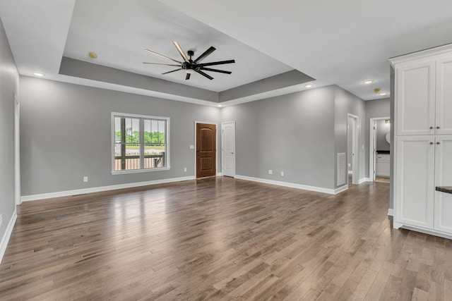 149 Watson Ct, Leoma, TN 38468 - unfurnished living room with a ceiling fan, a tray ceiling, baseboards, and wood finished floors