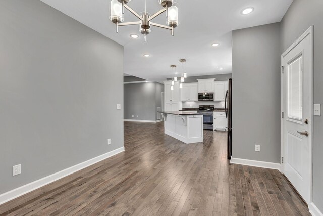 149 Watson Ct, Leoma, TN 38468 - kitchen with dark countertops, dark wood-style floors, white cabinets, appliances with stainless steel finishes, and a notable chandelier