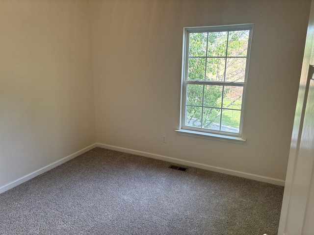 carpeted empty room featuring visible vents and baseboards