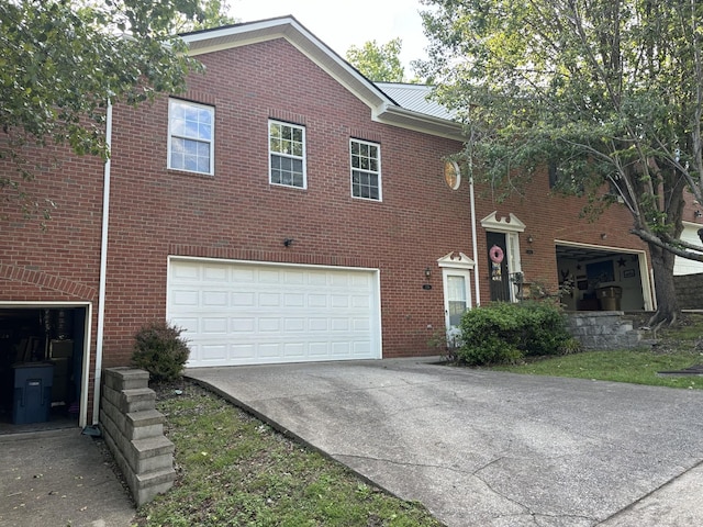 view of front facade with an attached garage, concrete driveway, and brick siding