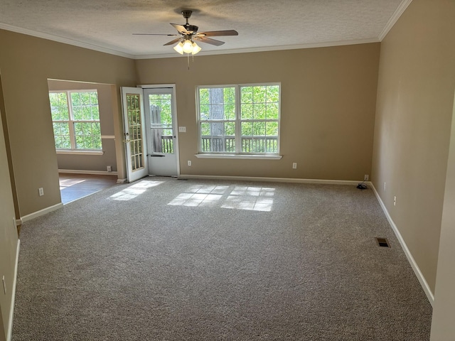 carpeted empty room with a textured ceiling, ceiling fan, ornamental molding, and a healthy amount of sunlight